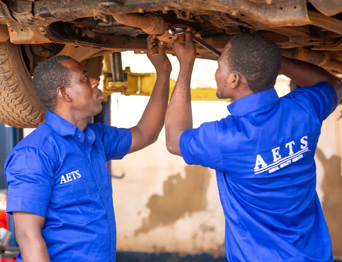 Technicians working underneath a raised vehicle