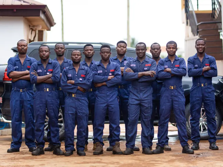 The AETS technical team lined up in front of the workshop