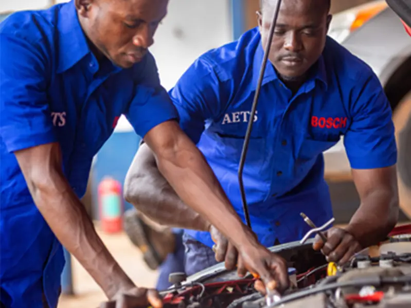 Two AETS technicians working on an engine
