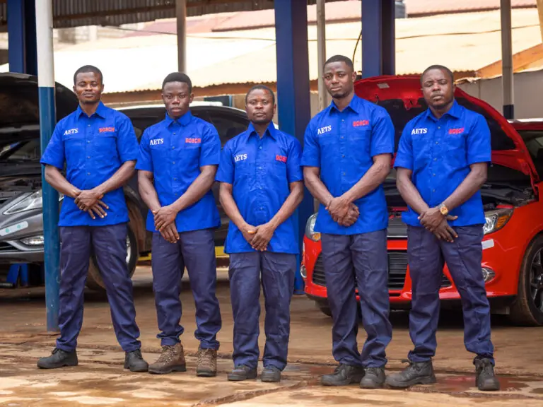 AETS certified technicians in uniform in front of the service bays